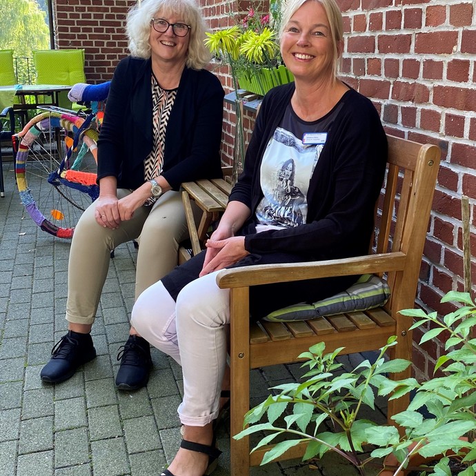 Ein Foto, auf dem Christiane Böhm und Reinhild Spanke draußen auf einer Bank sitzen.