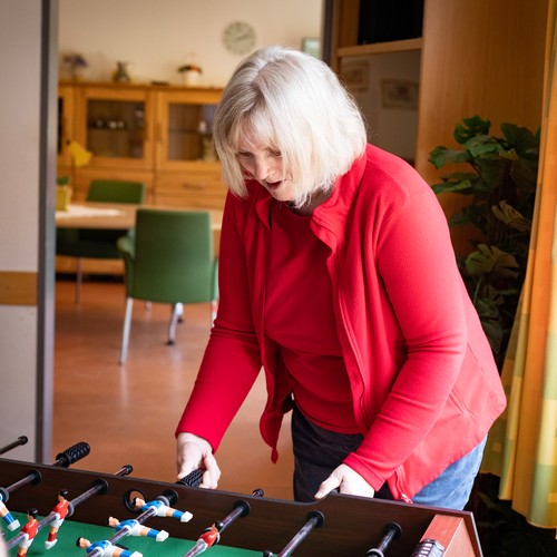 Eine Bewohnerin, die mit einer Pflegekraft kickert.